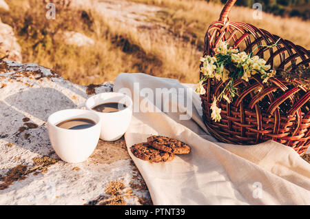 Picknick in der Natur. Zwei Kaffeetassen und Chocolate Chip Cookies Stockfoto