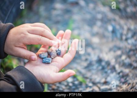 In der Nähe von kleines Mädchen Hände beim Spielen auf dem Boden mit Seele oder kleine Steine. Stockfoto