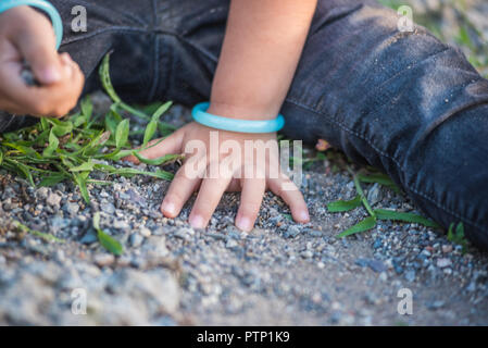 In der Nähe von kleines Mädchen Hände beim Spielen auf dem Boden mit Seele oder kleine Steine. Stockfoto