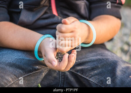 In der Nähe von kleines Mädchen Hände beim Spielen auf dem Boden mit Seele oder kleine Steine. Stockfoto