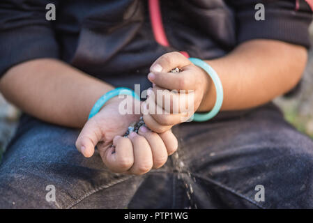 In der Nähe von kleines Mädchen Hände beim Spielen auf dem Boden mit Seele oder kleine Steine. Stockfoto