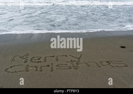 Frohe Weihnachten in den Sand und das Meer Läppen auf geschrieben Stockfoto