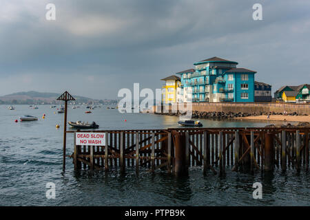 EXMOUTH, Devon, Großbritannien - 05 Okt 2018: Eingang nach Exmouth Docks mit den charakteristischen farbigen Wohngebäude in Shelly Straße hinter. Stockfoto