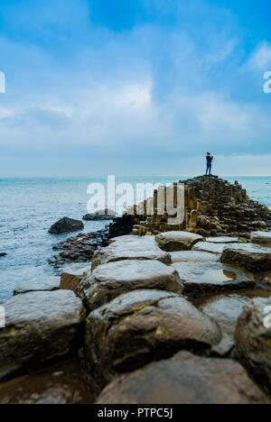 Touristen fotografieren auf Causeway Steine der berühmten Riesen" in Nordirland Stockfoto