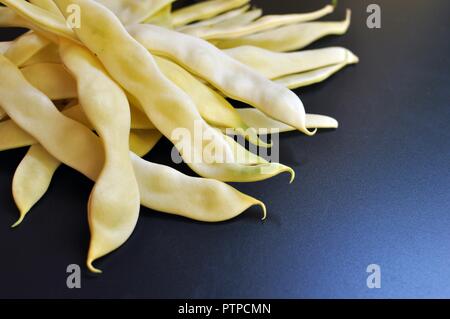 String gelb grün Frische Bohnen auf schwarzem Hintergrund. Ansicht von oben, kopieren Raum Stockfoto