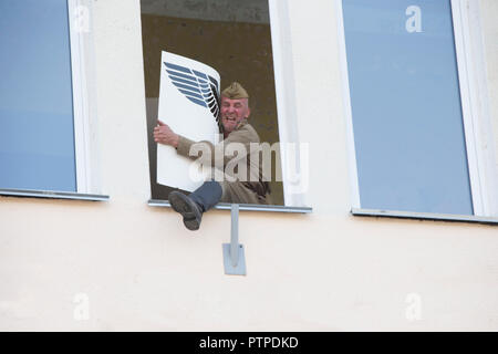 Belarus, Gomel. Mai 9, 2018. Der Tag des Sieges. Wiederaufbau, Reichstag. Russischer Soldat wirft, ein Poster mit einem Deutschen Hakenkreuz Stockfoto