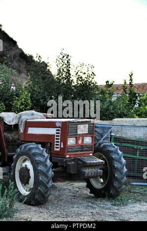 Almeria, Spanien - 23. September 2018: Alt und roten Traktor neben dem Garten an einem sonnigen Tag des Sommers geparkt Stockfoto