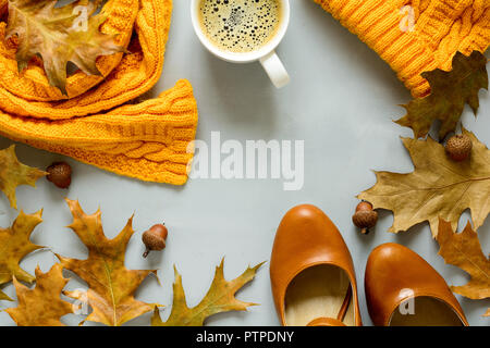 Feminine herbst Zubehör. Schal und Schuhe, Tasse Kaffee, eiche Blätter und Eicheln auf grau Holz- Hintergrund. Flach. Ansicht von oben. Platz kopieren Stockfoto