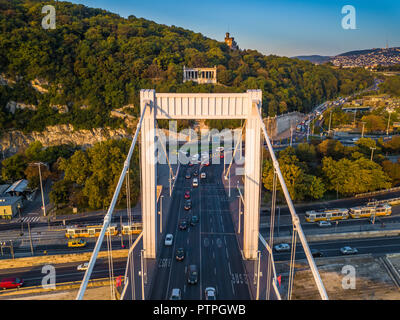 Budapest, Ungarn - Luftbild der Elisabeth Brücke (Erzsebet Hid) und Gellert Hill bei Sonnenaufgang mit starkem Verkehr und traditionellen gelben Straßenbahnen Stockfoto