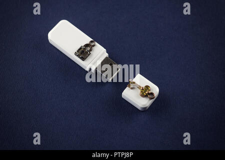 White flash drive mit Schloss und Schlüssel auf blauem Hintergrund an. Stockfoto