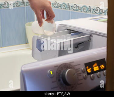 Das Mädchen schläft Pulver in der Waschmaschine, close-up Stockfoto