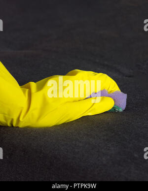 Mädchen in gelb Handschuhe reinigt das Sofa, close-up Stockfoto