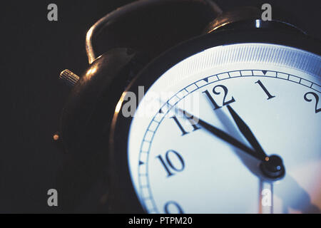 Fünf Minuten vor Mitternacht. Ändern der Uhren, Zeiteinstellung, Sommerzeit oder neues Jahr Konzept auf Retro analoge Uhr. Stockfoto