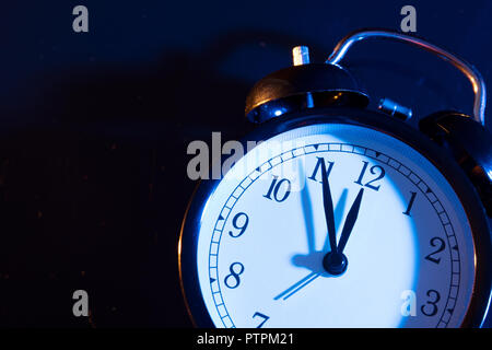 Fünf Minuten vor Mitternacht. Ändern der Uhren, Zeiteinstellung, Sommerzeit oder neues Jahr Konzept auf Retro analoge Uhr. Stockfoto