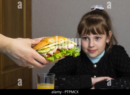 Mutter bereitet ein Sandwich für ein Kind in der Schule Stockfoto