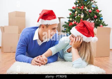 Junges Paar feiert Weihnachten in Ihrem neuen Zuhause. Stockfoto