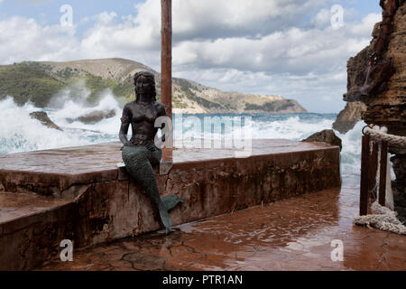 Storm Wellen von Cala Agulla Europa Spanien Küste in der Nähe von Cala Rajada, starker Sturm mit hohen Wellengang, Meer junge Frau Statue in der Tauchbasis Stockfoto