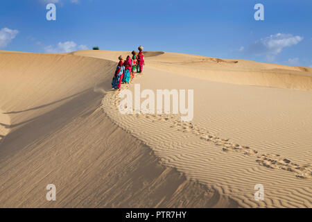 Das Bild der Rajasthani traditionelle Damen mit Töpfe in den Sanddünen von Jaisalmer, Rajasthan, Indien Stockfoto