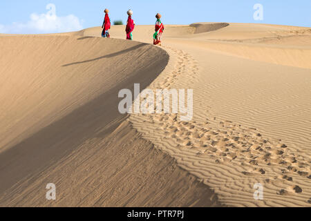 Das Bild der Rajasthani traditionelle Damen mit Töpfe in den Sanddünen von Jaisalmer, Rajasthan, Indien Stockfoto