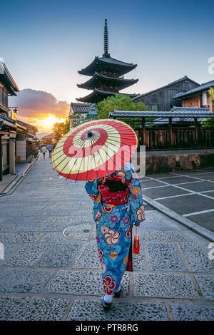 Frau mit traditionellen japanischen kimono mit Regenschirm im Yasaka Pagode und Sannen Zaka Straße in Kyoto, Japan. Stockfoto