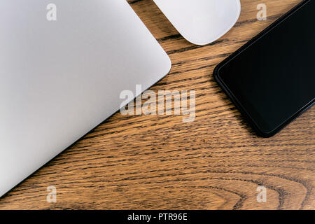 Laptop und Smartphone, Maus auf dem Tisch. Office Konzept. Stockfoto