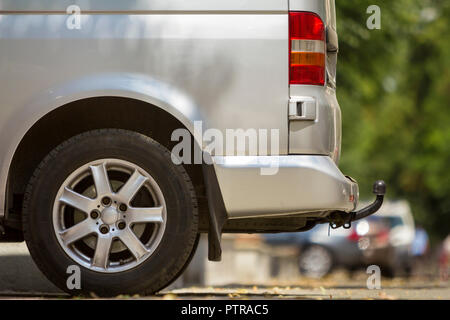 Close-up Seite Detail anzeigen Silber Passagier mittelgroß Luxus Minibus Transporter mit Zugöse auf Sommer sonnigen Stadt Straße Bürgersteig mit unscharfen Sil geparkt Stockfoto