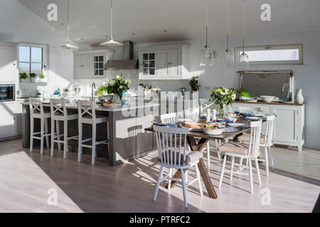 Küche und Esszimmer mit Meerblick Barhockern an der Insel mit Esstisch und Stühle im sonnigen Küsten Home öffnen Stockfoto