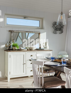 Küche und Esszimmer mit Meerblick Shaker - style Sideboard und Spiegel mit Esstisch in Küsten Home öffnen Stockfoto