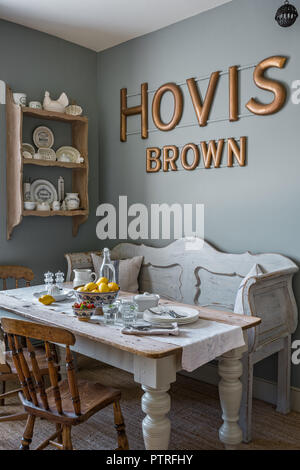 16. Jahrhundert Bauernhaus Sanierung' HOVIS' Schriftzug oben Sitzbank und Tisch mit Vintage Geschirr an die Wand montiert Fachböden im 16. Jahrhundert restauriert Stockfoto