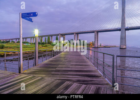 Pier durch den Fluss Tejo im Parque das Nacoes - Vasco da Gama Brücke im Hintergrund (Lissabon, Portugal) Stockfoto