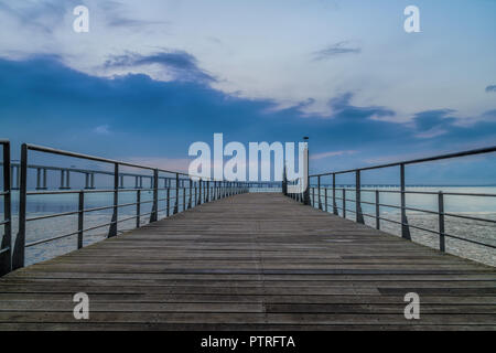 Pier durch den Fluss Tejo im Parque das Nacoes - Vasco da Gama Brücke im Hintergrund (Lissabon, Portugal) Stockfoto