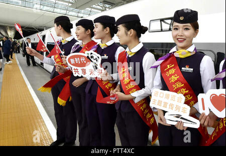 (181010) - SHANGHAI, Oktober 10, 2018 (Xinhua) - Begleiter der G2 Bullet Zug halten Schilder der ersten China International Import Expo (CIIE) an Hongqiao Bahnhof im Osten Chinas Shanghai, Okt. 10, 2018 zu fördern. Eisenbahnverwaltungen haben eine Kampagne am Mittwoch der kommenden Ersten CIIE auf bullet Züge auf der Hochgeschwindigkeitsstrecke Beijing-Shanghai zu fördern. (Xinhua / Chen Fei) (lmm) Stockfoto