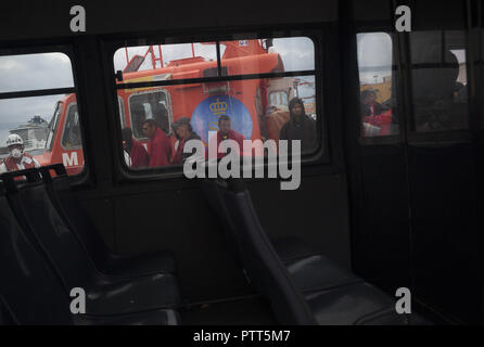 Malaga, Malaga, Spanien. 10 Okt, 2018. Migrantinnen und Migranten sind auf einem Rettungsboot durch einen Polizeiwagen, während Sie warten, aussteigen bei Ihrer Ankunft im Hafen von Málaga in Spanien Maritime Rescue Service 44 maghrebinischen Migrantinnen gerettet, die Mehrheit von ihnen gesehen werden vom Rif an Bord eines Beiboot am Mittelmeer und brachte sie nach Malaga Hafen, von wo aus sie durch das Spanische Rote Kreuz unterstützt wurden. Credit: Jesus Merida/SOPA Images/ZUMA Draht/Alamy leben Nachrichten Stockfoto