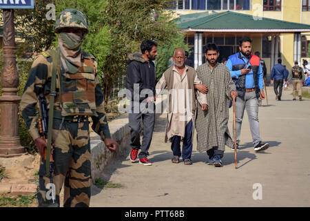 Oktober 10, 2018 - Baramulla, Jammu und Kaschmir, Indien - Ghulam Ahmed (80 Jahre alt) von zwei Männern durchgeführt, nachdem seine Stimmabgabe im Wahllokal Sumbal während der Wahlen.. Zweite Phase der städtischen lokalen Körper (ULB) Wahlen in Jammu und Kaschmir. Sommer Hauptstadt des Indischen kontrollierten Kashmir, Srinagar. Dieser hatte den niedrigsten Umsatz der Wähler bei den Kommunalwahlen. (Bild: © idrees Abbas/SOPA Bilder über ZUMA Draht) Stockfoto