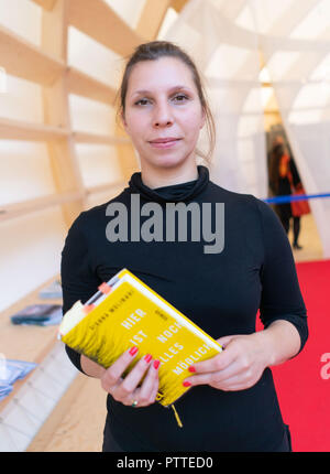 11 Oktober 2018, Hessen, Frankfurt Main: Der Schweizer Autor Gianna Molinari steht mit ihrem Buch in der Hand auf der Frankfurter Buchmesse. Größte Buch der Welt zeigen, dauert bis zum 14. Oktober 1999 statt. Foto: Frank Rumpenhorst/dpa Stockfoto