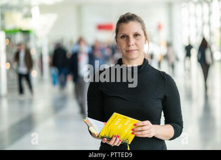 11 Oktober 2018, Hessen, Frankfurt Main: Der Schweizer Autor Gianna Molinari steht mit ihrem Buch in der Hand auf der Frankfurter Buchmesse. Größte Buch der Welt zeigen, dauert bis zum 14. Oktober 1999 statt. Foto: Frank Rumpenhorst/dpa Stockfoto