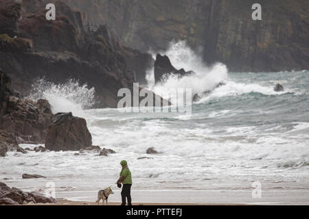 Süßwasser-Ost, Pembrokeshire, Wales, 11 Uhr Oktober 2018. UK Wetter: Nass stürmisches Wetter beginnt für schwere See mit Sturm Callum für eine stürmische Wochenende voran zu stellen. Pembrokeshire, Wales. Ein einsamer Hund Walker mit ihren Husky trotzen den nassen und windigen Wetter an der Küste, wie Wellen in der Küstenlinie bei Süßwasser-Ost, Pembrokeshire Â© DGDImages/AlamyNews Stockfoto