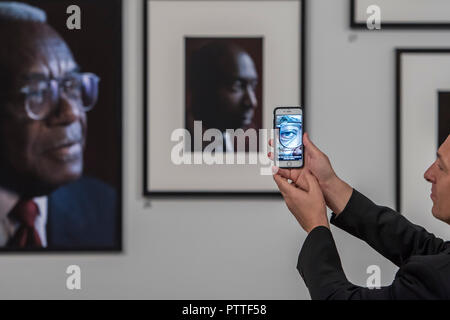 London, Großbritannien. 10. Oktober, 2018. Mithilfe des App, in der Sie sehen können, die Personen Interview an Ihrem Portrait hingewiesen - Schwarz ist das neue Schwarz: Porträts von Simon Friedrich in der National Portrait Gallery, London, größte Akquisition der Galerie Porträts von afro-karibischen (auf Anzeige bis 27. Januar 2019). Credit: Guy Bell/Alamy leben Nachrichten Stockfoto