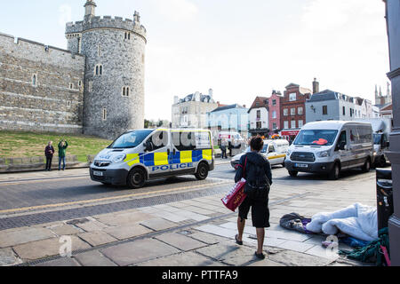 Windsor, Großbritannien. 11. Oktober, 2018. Ein polizeifahrzeug übergibt einen Obdachlosen schlafen auf dem Gehsteig gegenüber von Schloss Windsor am Vorabend der Hochzeit von Prinzessin Eugenie, Enkelin der Königin, und ihr Freund von rund sieben Jahren Jack Brooksbank. Credit: Mark Kerrison/Alamy leben Nachrichten Stockfoto