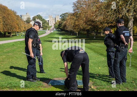 Windsor, Großbritannien. 11. Oktober, 2018. Polizisten inspizieren ein kanaldeckel neben dem langen Spaziergang vor Windsor Castle als Teil der Vorbereitungen am Vorabend der Hochzeit von Prinzessin Eugenie, Enkelin der Königin, und ihr Freund von rund sieben Jahren Jack Brooksbank. Credit: Mark Kerrison/Alamy leben Nachrichten Stockfoto