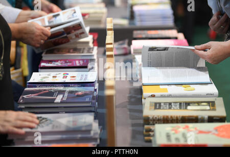 Frankfurt am Main, Deutschland. 11. Oktober, 2018. 11 Oktober 2018, Hessen, Frankfurt Main: die Besucher der Frankfurter Buchmesse Blatt durch Bücher bei einer Veröffentlichung stehen. Größte Buch der Welt zeigen, dauert bis zum 14. Oktober 1999 statt. Foto: Arne Dedert/dpa Quelle: dpa Picture alliance/Alamy leben Nachrichten Stockfoto