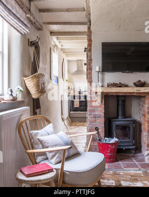 Abisolierten Ercol Stil Sessel und Holzofen in Backstein Kamin Stockfoto