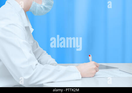Der Arzt im weißen Kittel am Tisch sitzt und der Unterzeichnung des Dokuments. Close-up. Stockfoto