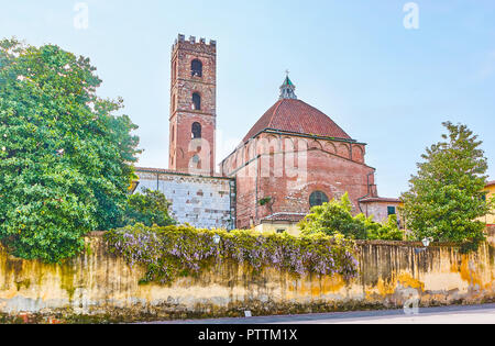 Der Blick von der Antelminelli Platz auf der Rückseite der Kirche der Heiligen Johannes und Reparata mit inne Garten hinter dem Zaun, Lucca, Italien Stockfoto