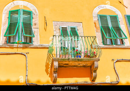 Der schöne Balkon und zum nächsten Fenster mit typischen italienischen grünen Fensterläden in der Altstadt von Lucca, Italien Stockfoto