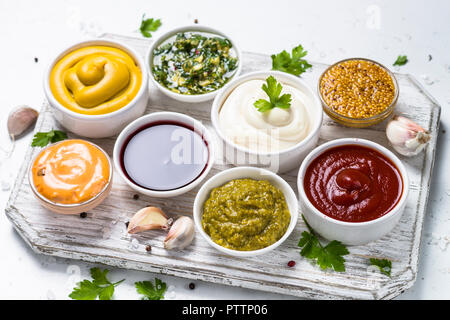 Satz von Saucen - Ketchup, Mayonnaise, Senf Soja Sauce, bbq Sauce, Pesto, Chimichurri, Senf Körner und Granatapfel Soße auf weißem Hintergrund. Stockfoto