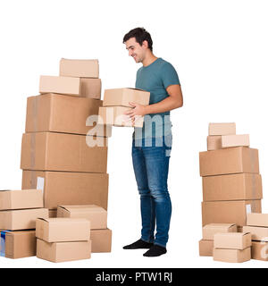 In voller Länge Porträt des jungen Mannes, die Verpackung in Kisten bereit, in ein anderes Haus auf weißem Hintergrund zu bewegen. Home Umzüge Lieferung Konzept. Stockfoto