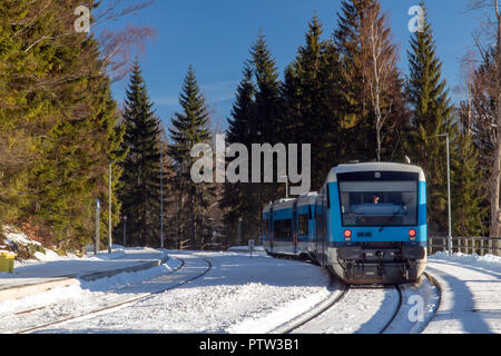 Die verschneite Bahnhof mit dem Zug in die Berge. Den leeren Ablagetisch mit Regionalbahn im Winter Natur. Harrachov, Berge Krkono Stockfoto