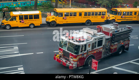 Schulbusse Line up vor PS 33 in Chelsea in New York mit einem fdny Engine über die Straße am Freitag, 5. Oktober 2018 gestoppt. (© Richard B. Levine) Stockfoto