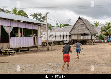 Puerto Miguel Peru, Südamerika. Native Menschen zu Fuß neben ihren Häusern auf Stelzen in das Dorf Puerto Miguel gebaut. (Für die redaktionelle Nutzung) Stockfoto